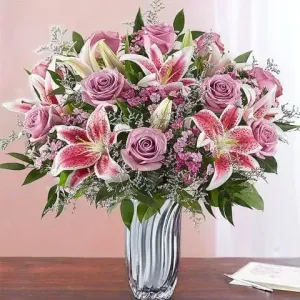 Λαμπερή, γιορτινή και πλούσια floral δημιουργία με ολόφρεσκα λουλούδια για ευχές χρόνια πολλά σε κομψή συσκευασία δώρου