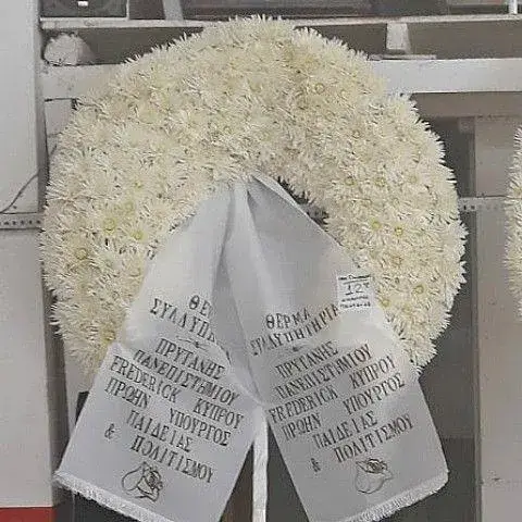 Μεγαλοπρεπές στεφάνι κηδείας με ολόφρεσκα λευκά άνθη και κομψή κορδέλα συλλυπητηρίων